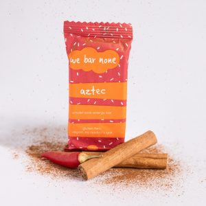 We Bar None Aztec wholefoods energy bar surrounded by cinnamon sticks and a chilli